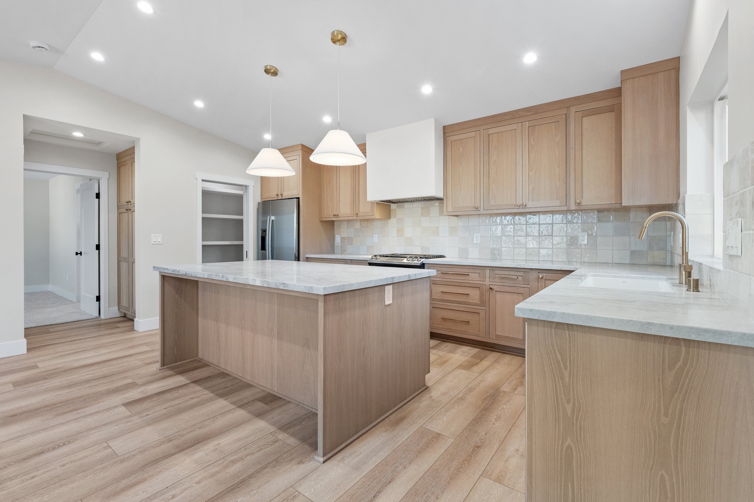 Natural wood kitchen cabinetry with a matching island